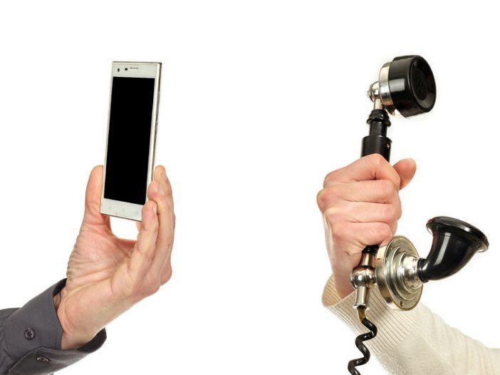 Skype for Business enabled mobile phone shown with antique phone