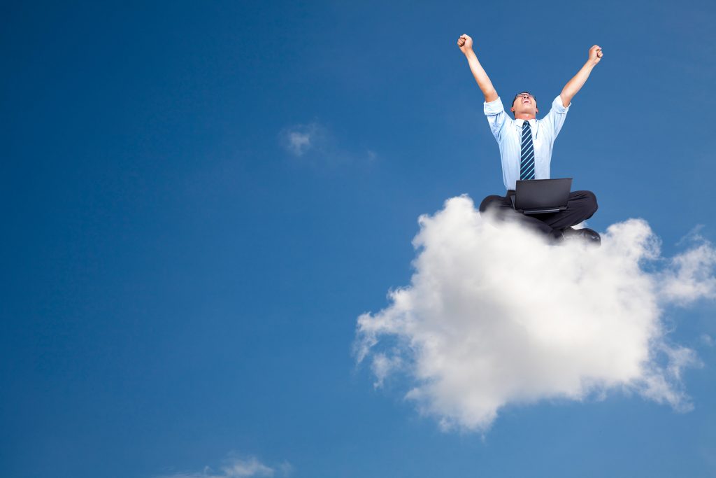 man in a suit sitting on a cloud with hands in the air celebrating