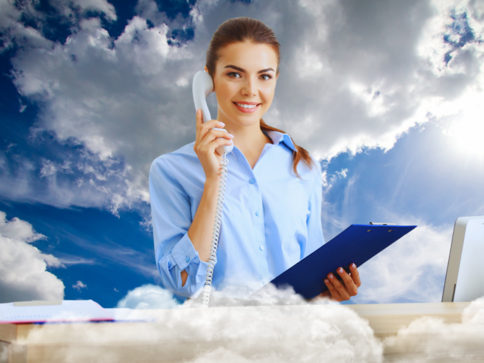 Woman at a desk in the clouds happily taking a phone call.