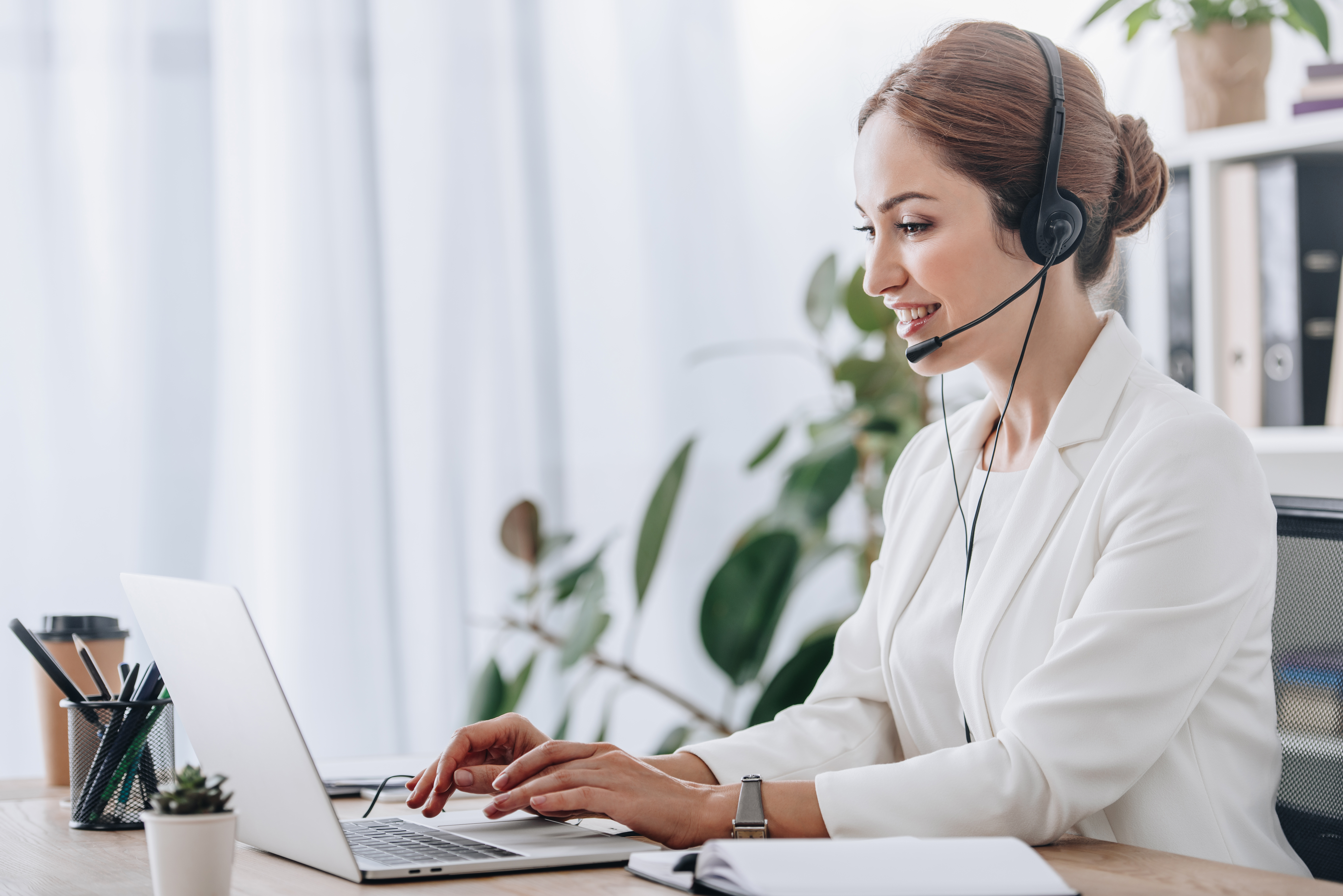 Professional woman wearing headset in front of a laptop 219566796